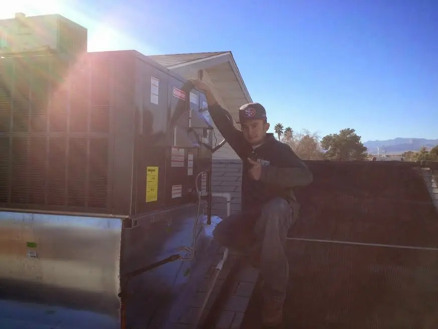 HVAC technician performing Air Duct Repair on a rooftop unit in Fruitland Park